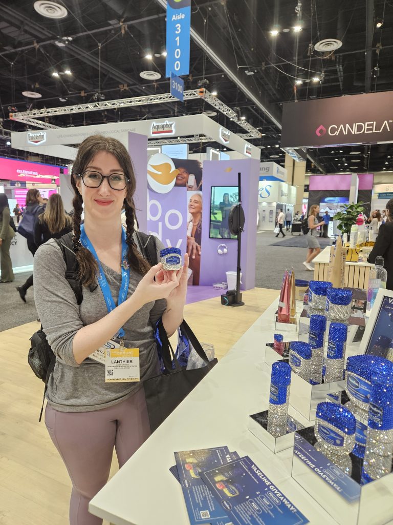 Image of Jaclyn in the exhibitor hall holding up a rhinestoned jar of Vaseline.